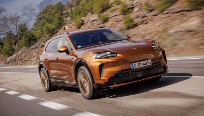 Porsche Cayenne Electric 2026 warna abu-abu melaju kencang di lintasan Barcelona, menonjolkan desain SUV listrik mewah dan aerodinamis. (CAR AND DRIVER)