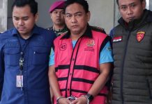 Skandal Korupsi Nikel: Ketua Ombudsman RI Jadi Tersangka, Diduga Terima Suap Rp1,5 Miliar Aparat Kejaksaan Agung mengawal tersangka Hery Susanto menuju mobil tahanan di Gedung Bundar Jampidsus Jakarta.